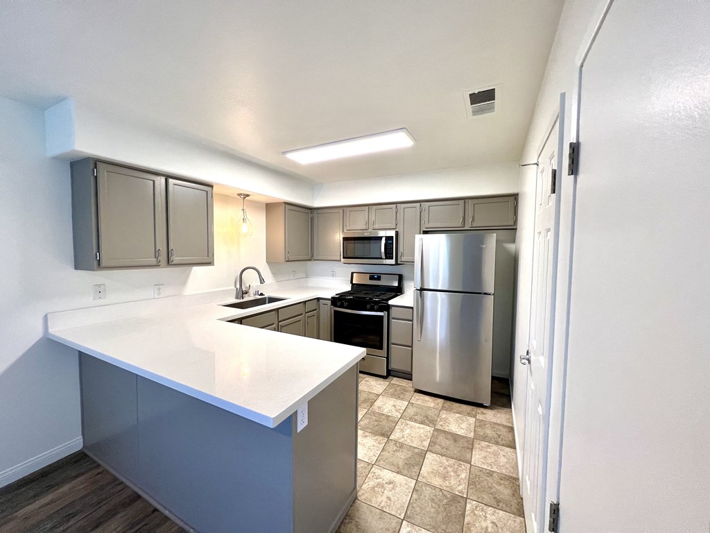 a kitchen with white countertops and stainless steel appliances at Villa Mondavi, Bakersfield